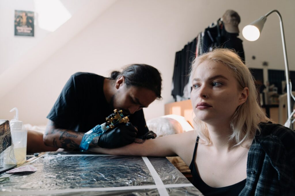 A Blonde Woman Getting a Tattoo on her Arm