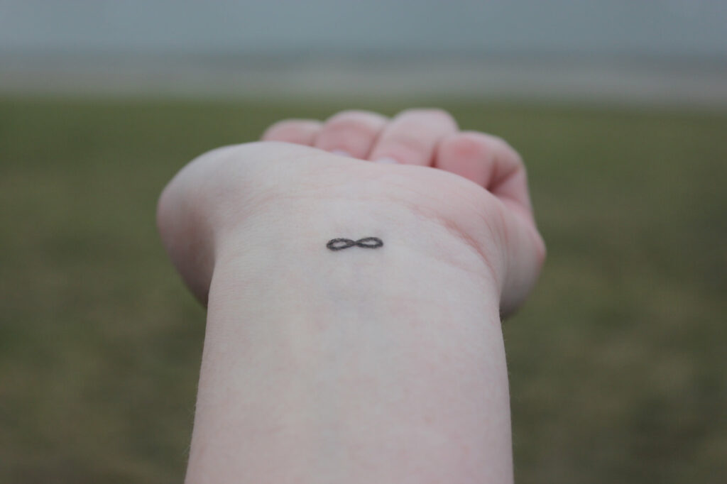 Closeup of the arm with an infinity symbol tattooed