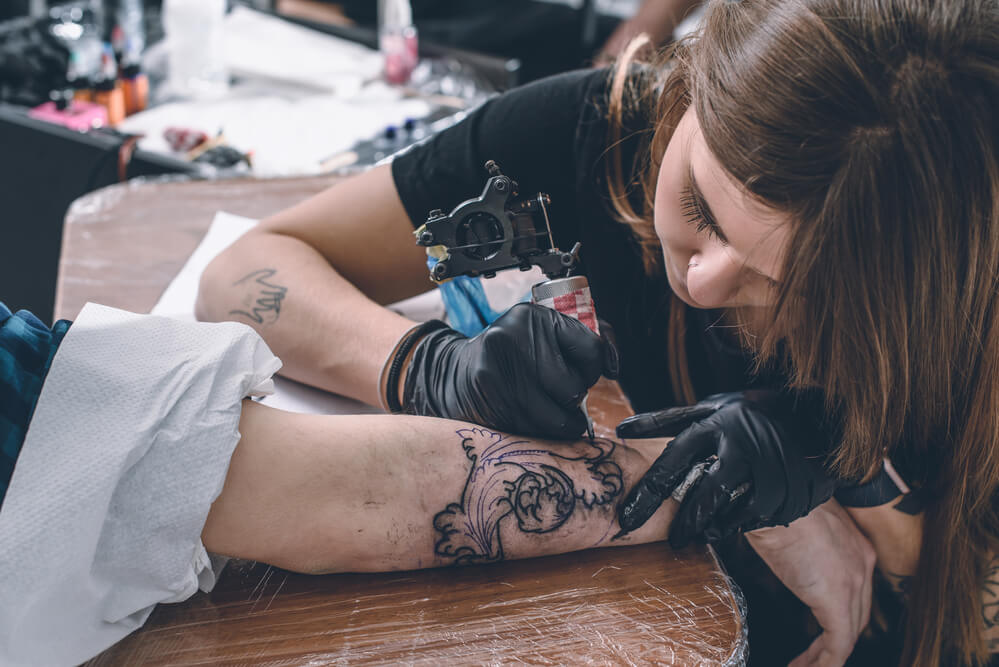 Female tattoo master during work in studio