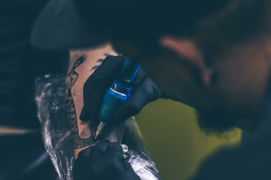 Man Tattooing Person on Arm